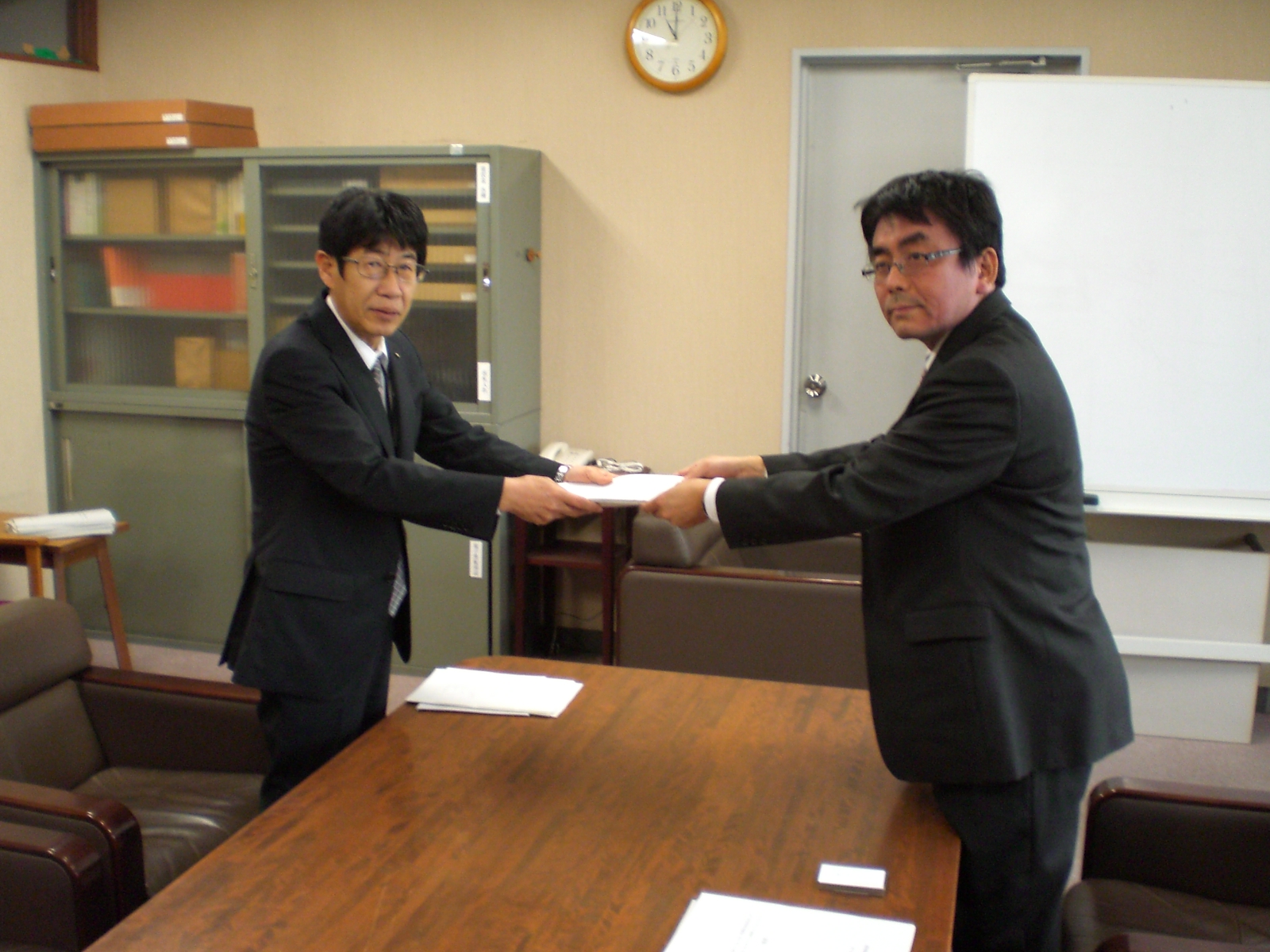 高田議長が橋本教育次長に提言を手渡しています
