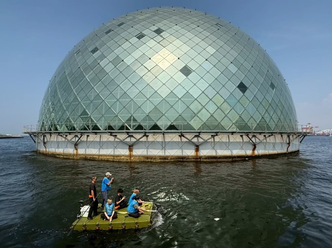 THE JEWELRYの前でサップボートに乗った学生たちが水上ごみ拾いをしている様子