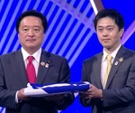 閉幕式で若宮大臣とともにBIE旗を受け取る知事