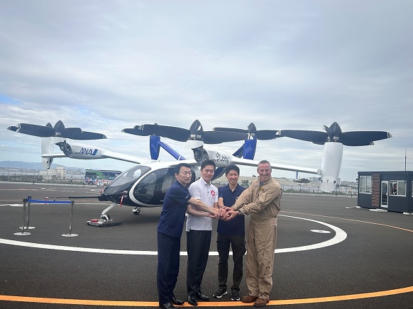 空飛ぶクルマの機体の前でANAホールディングス株式会社 代表取締役 副社長執行役員 平澤寿一氏及びJoby Aviation Inc. 日本事業責任者 小早康之氏らと記念撮影を行う知事