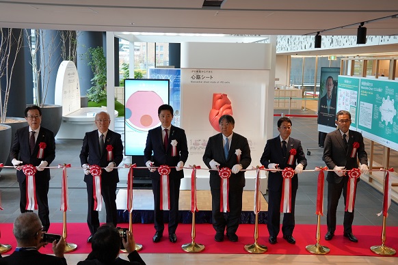 心臓模型の前でテープカットをする知事