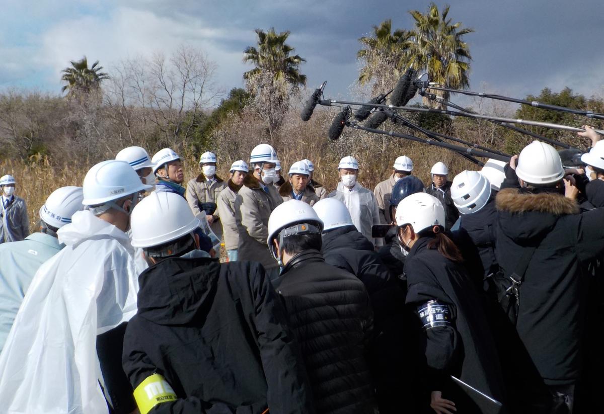 博物館の専門家の説明を聞きつつ、クジラの掘り起しを見守る知事