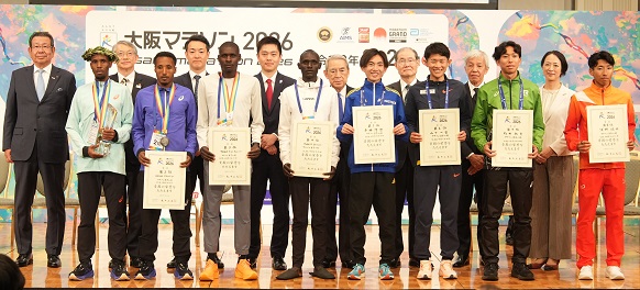 マラソン男子1位から8位入賞者及び他のプレゼンターとともに記念撮影をする知事