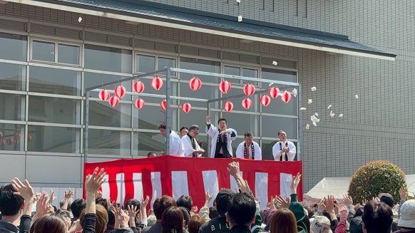 舞台上で餅まきに参加する知事