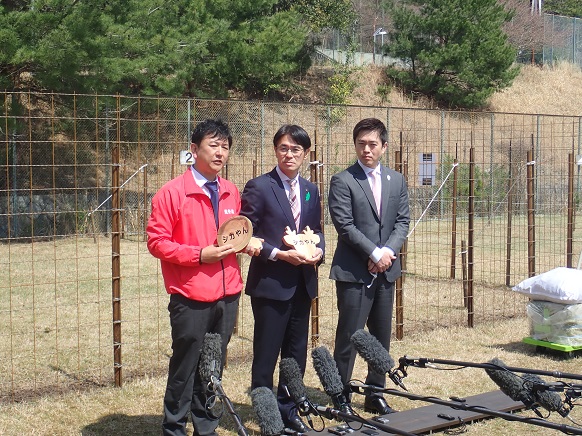 シカやんを命名した能勢温泉の西山社長、奈良県山下知事とともに、シカ保護場所の前で取材に応じている知事