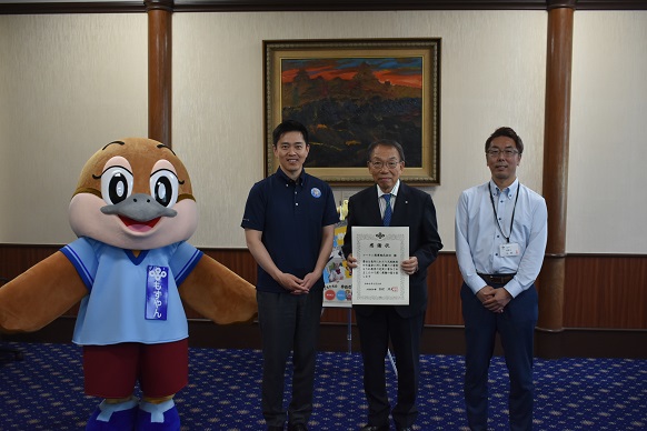 コーナン商事株式会社 成田常務取締役上席執行役員、もずやん、水野教育長と記念写真を撮影する知事