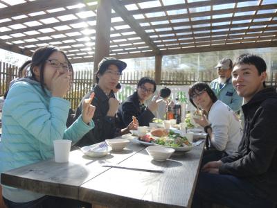 参加者が笑顔で焼き立てのピザを食べている様子