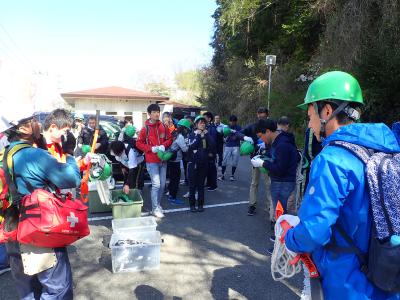 ヘルメットとのこぎりを受取っている様子