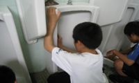 地域の保護者と生徒たちが校内のすべての便器を真っ白に磨きます