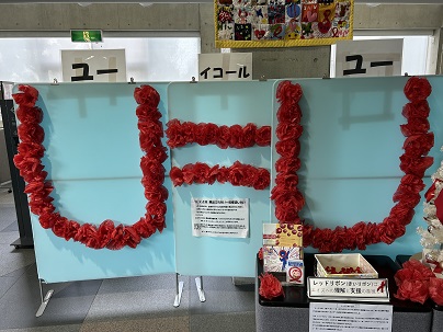 【写真】薔薇のような真っ赤な装飾文字の掲示「U = U（ユー イコール ユー）」