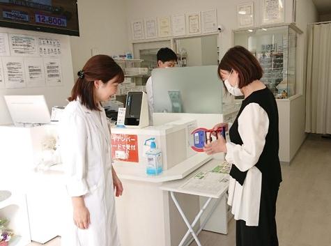 薬局で握力測定を通してフレイルの啓発をする様子