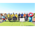 大阪平野をバックに関係者と記念撮影する知事