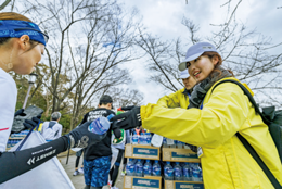 ボランティアスタッフがランナーに飲料を手渡す様子